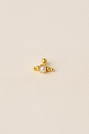 Gold earring with a central pearl on a beige background