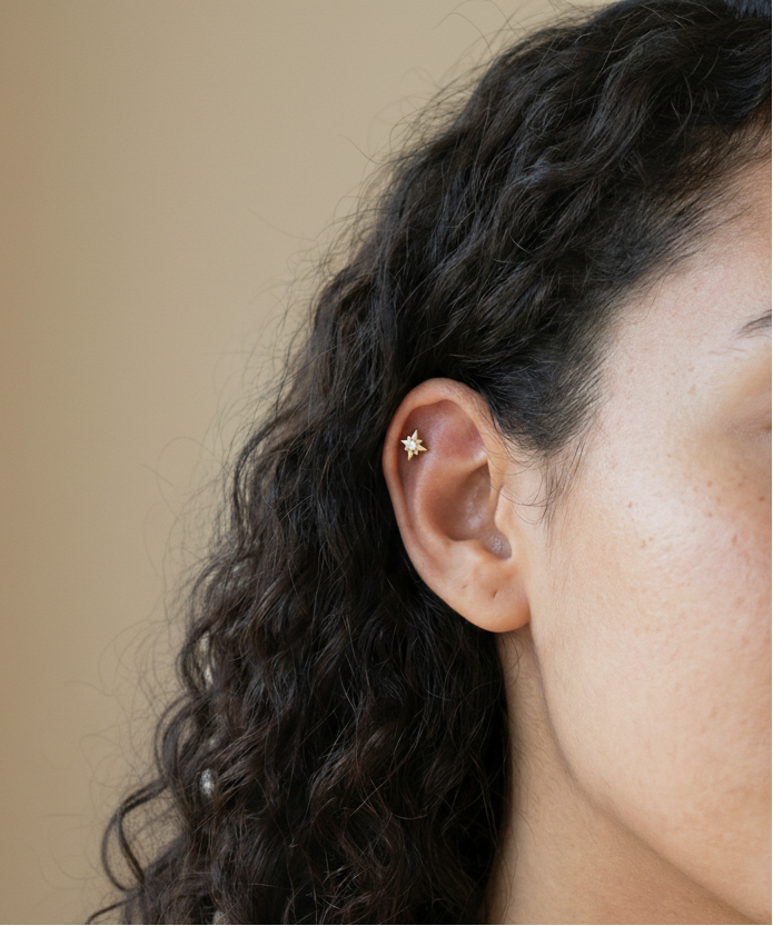 Close-up of a woman with curly hair and a star-shaped earring.