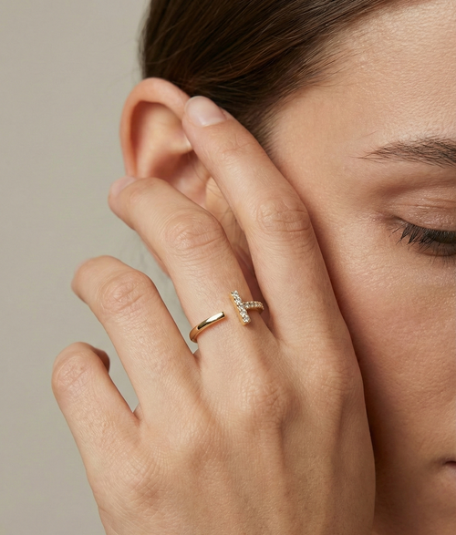 Close-up of a hand with a diamond ring on a neutral background